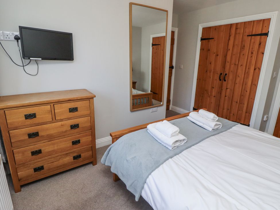 A bedroom with a bed and dresser at Rosefinch in Lucker