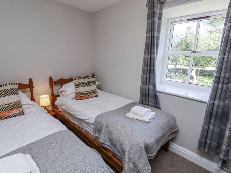 A bedroom with two beds and a window at Rosefinch in Lucker