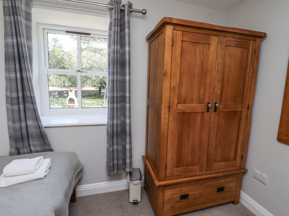 A bedroom with a wardrobe and window at Rosefinch in Lucker