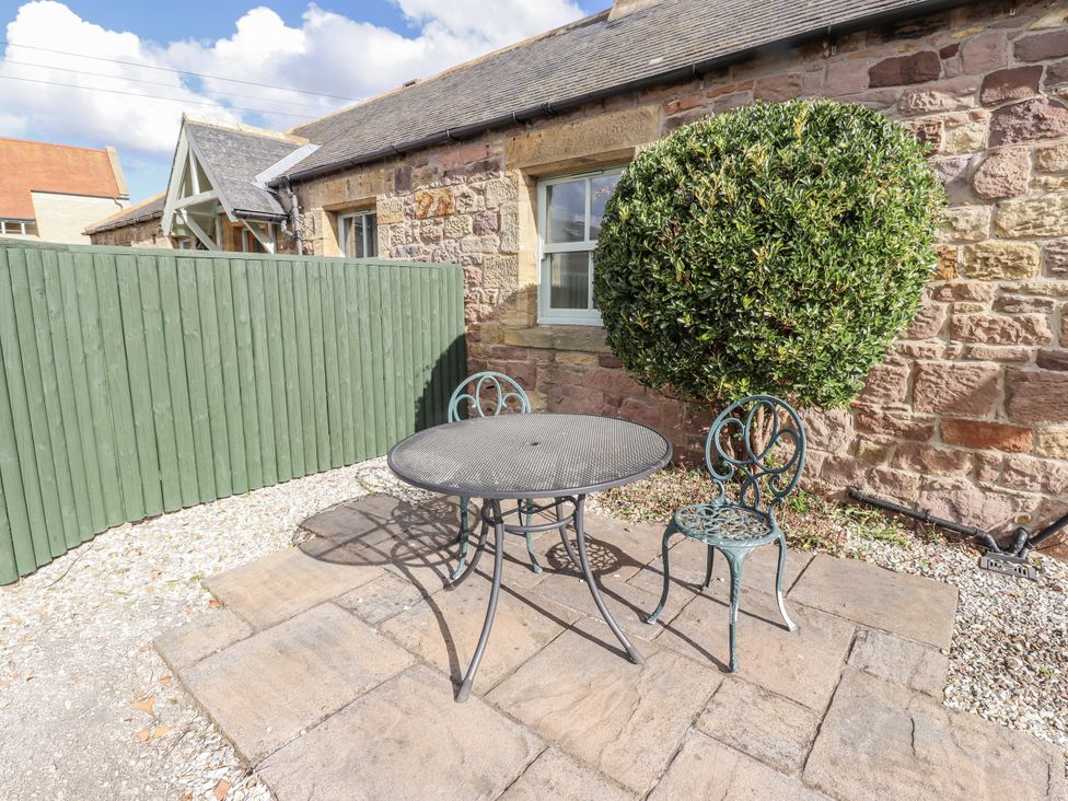An outdoor area with a table and chairs at Rosefinch in Lucker