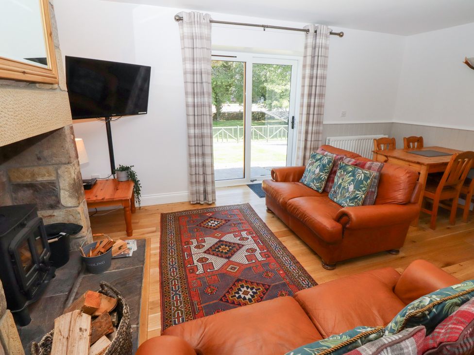 A living room with a sofa and dining table at Chaffinch in Lucker