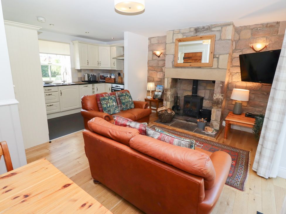 A living room with a sofa and fireplace at Chaffinch in Lucker