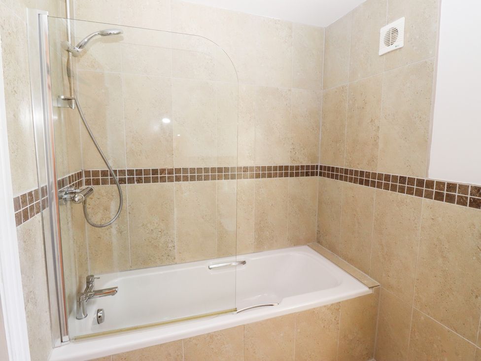 A bathtub with shower features at Chaffinch in Lucker