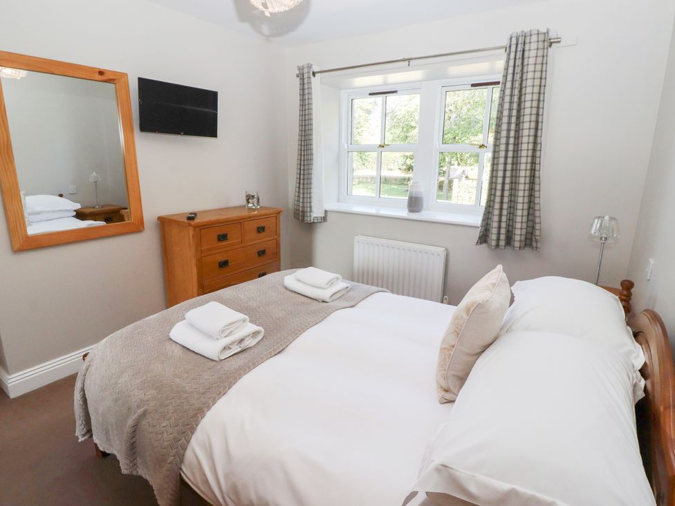 A bedroom with a bed and dresser at Chaffinch in Lucker