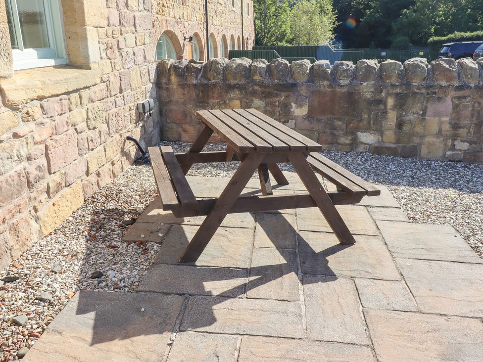 A picnic table on a patio in the garden at Chaffinch in Lucker