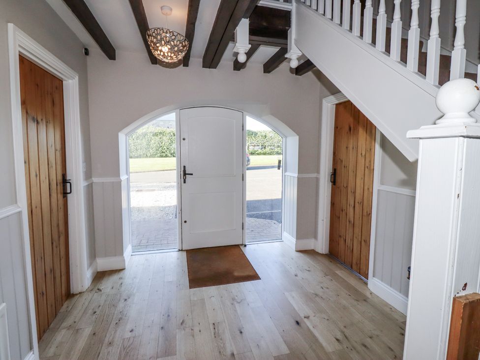 A hallway with front door and staircase at Goldfinch in Lucker