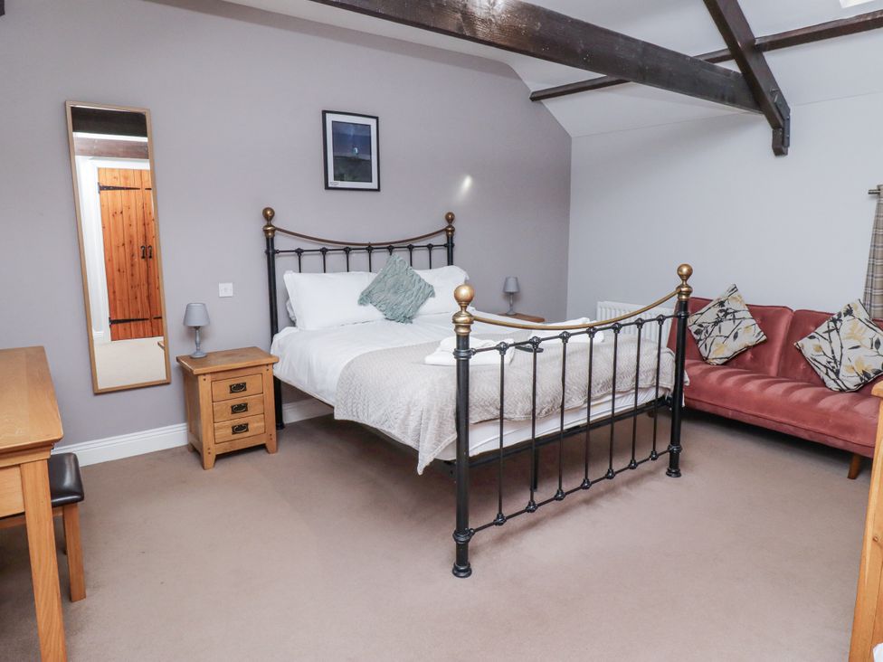 A bedroom with a bed and mirror at Goldfinch in Lucker