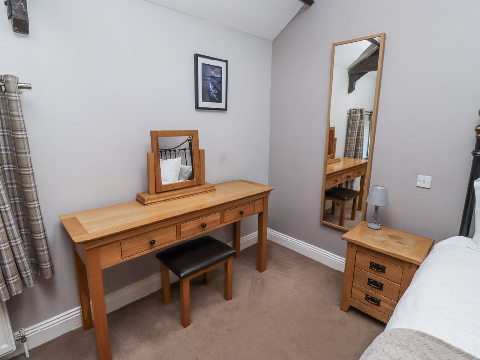 A bedroom with a dressing table and mirror at Goldfinch in Lucker
