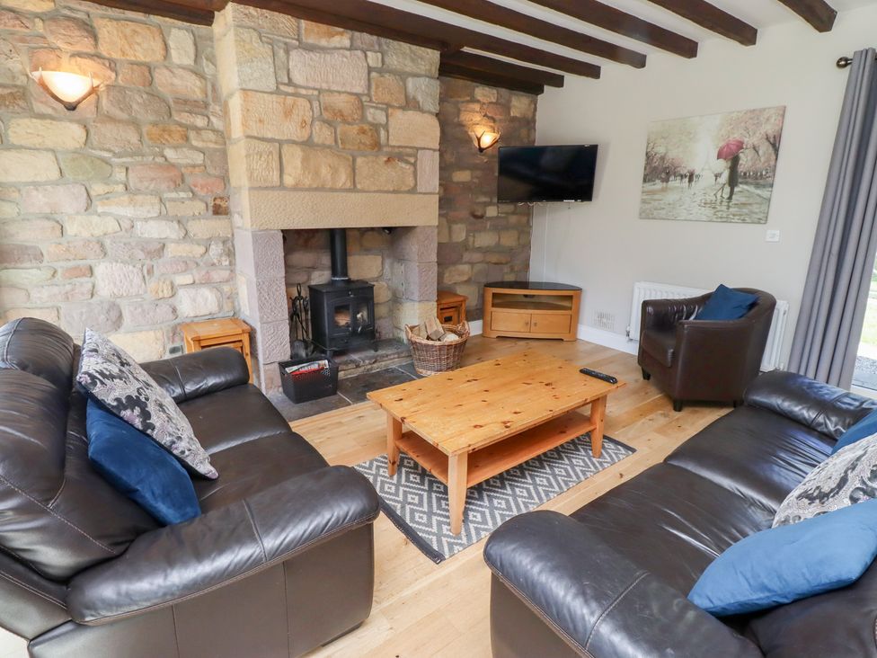 A living room with a fireplace and sofa at Bullfinch in Lucker