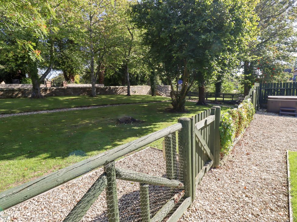 A garden with trees and a fence at Bullfinch in Lucker