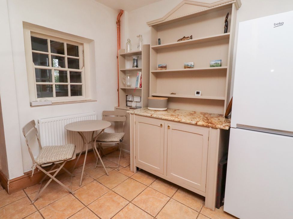 A kitchen with a table and chairs at Adderstone Cottage in Bamburgh