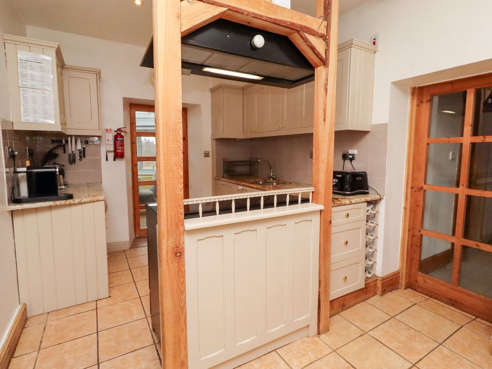 A kitchen with cabinets and a stove at Adderstone Cottage in Bamburgh