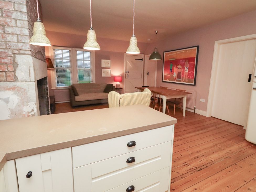 A living room with a sofa and dining table at Armstrong Cottages No6 in Bamburgh