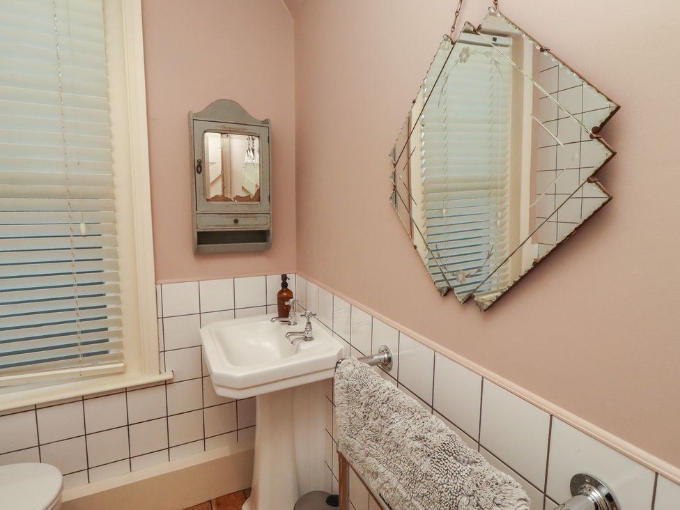 A bathroom with a sink and towel rack at Armstrong Cottages No6 Bamburgh