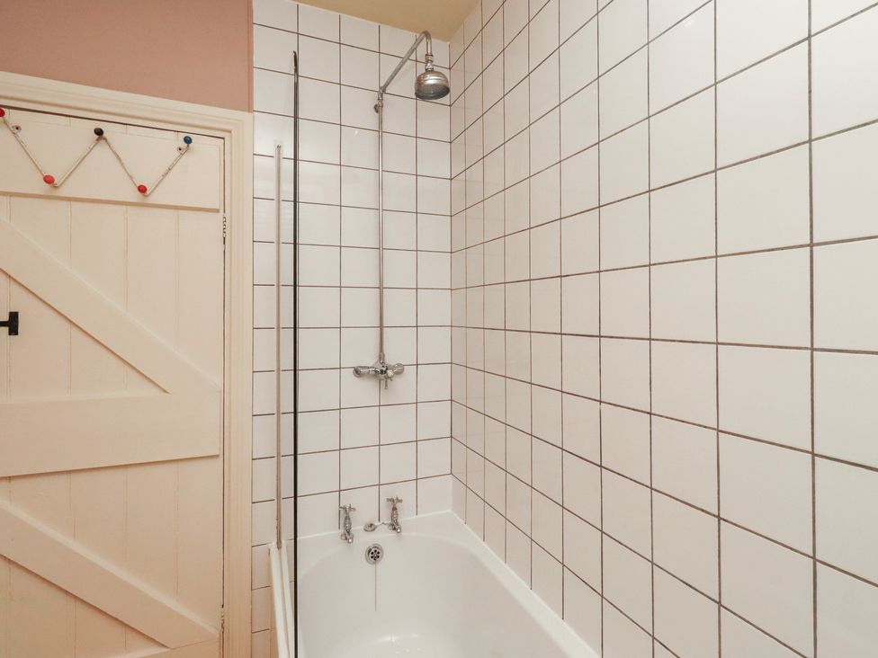 A bathroom with a bathtub and shower at Armstrong Cottages No6 Bamburgh