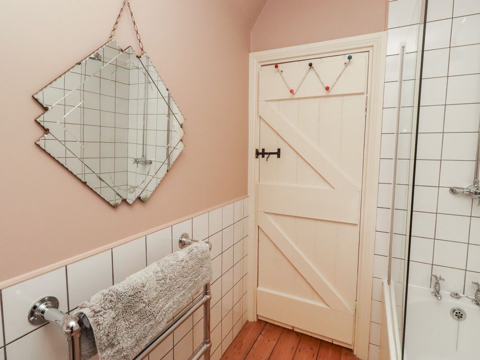 A bathroom with a mirror and towel rail at Armstrong Cottages No6 Bamburgh