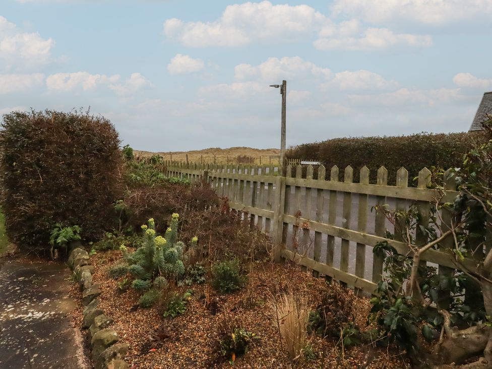 A garden area with a fence and plants at Armstrong Cottages No6 Bamburgh