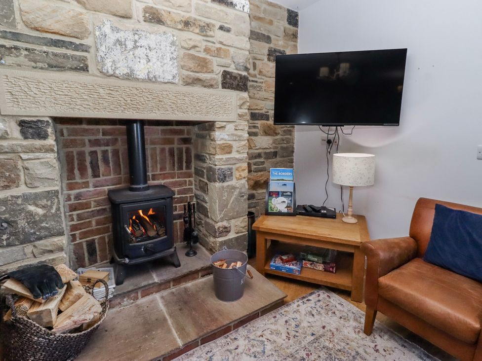 A living room with a fireplace and television at Goosander in Bamburgh