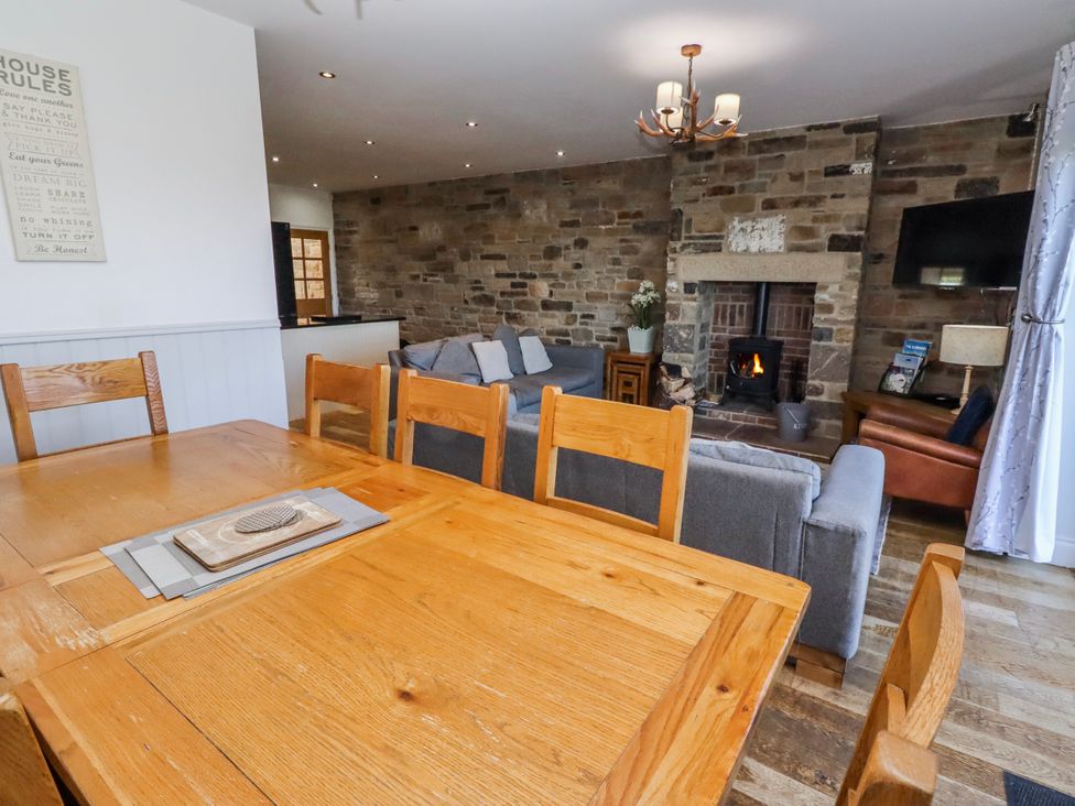 A living room with a sofa and fireplace at Goosander in Bamburgh