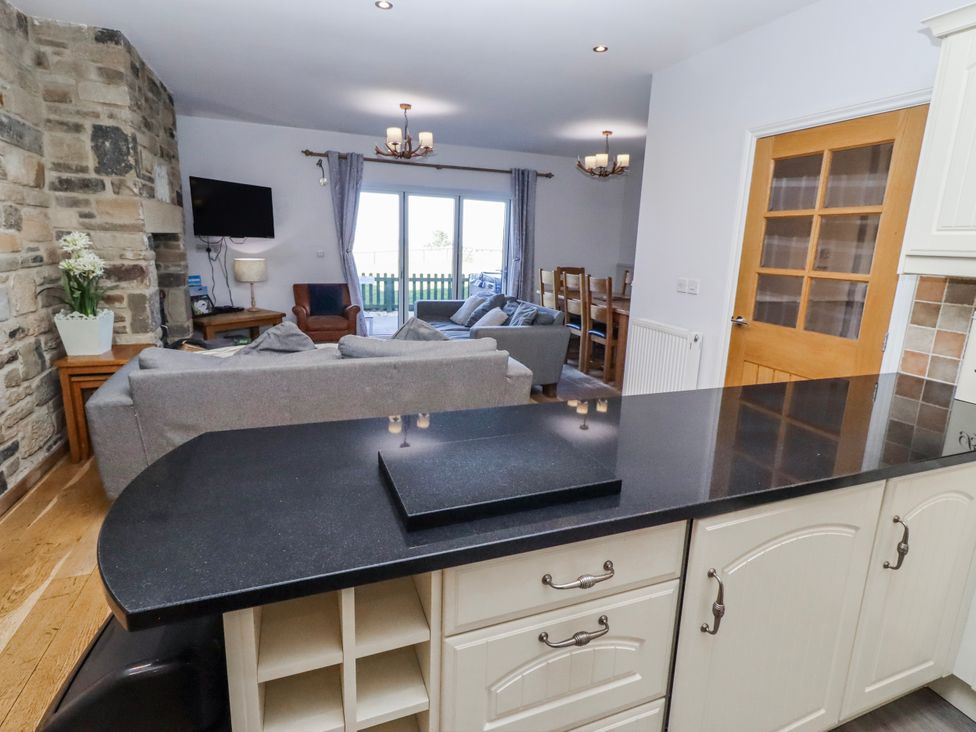 A living room with a sofa and dining table at Goosander in Bamburgh