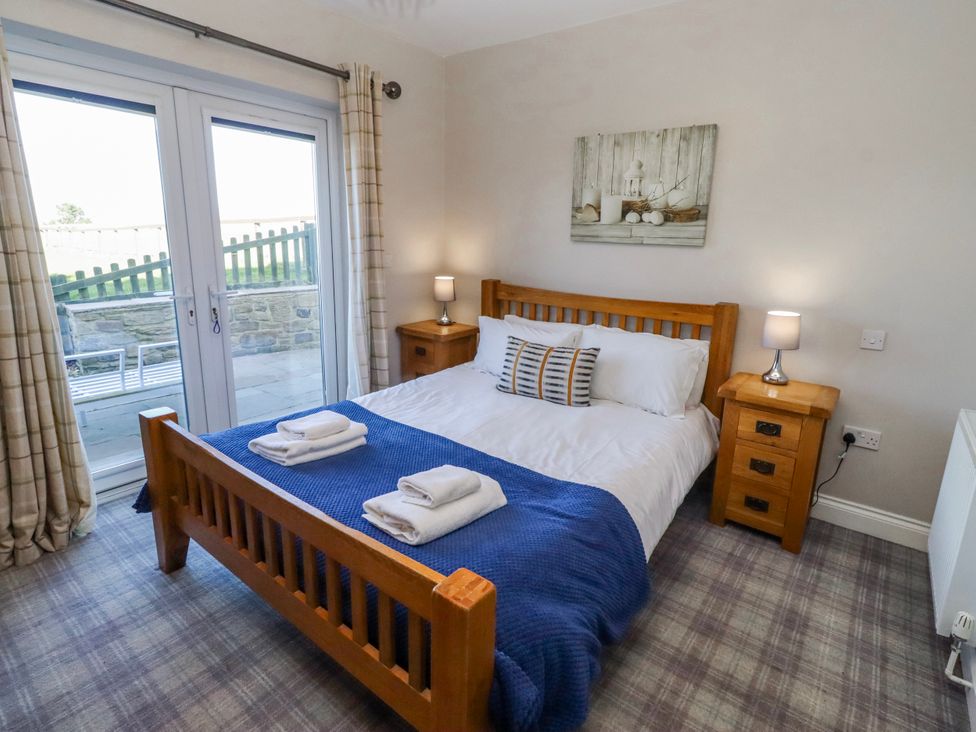 A bedroom with a double bed and bedside tables at Goosander in Bamburgh