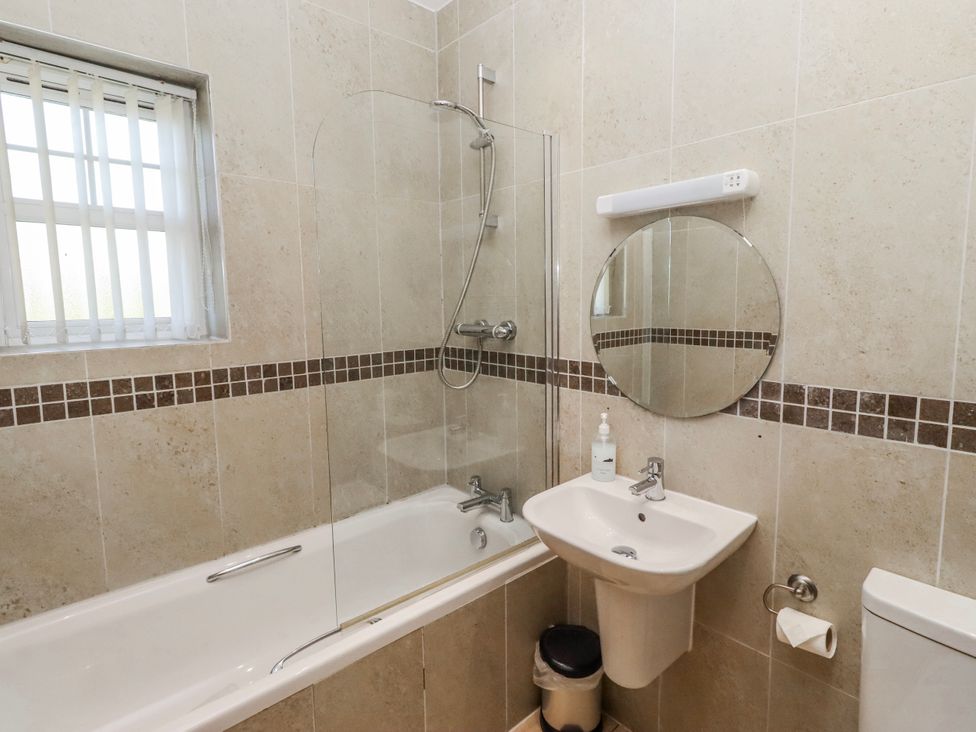 A bathroom with a bathtub and shower at Goosander in Bamburgh