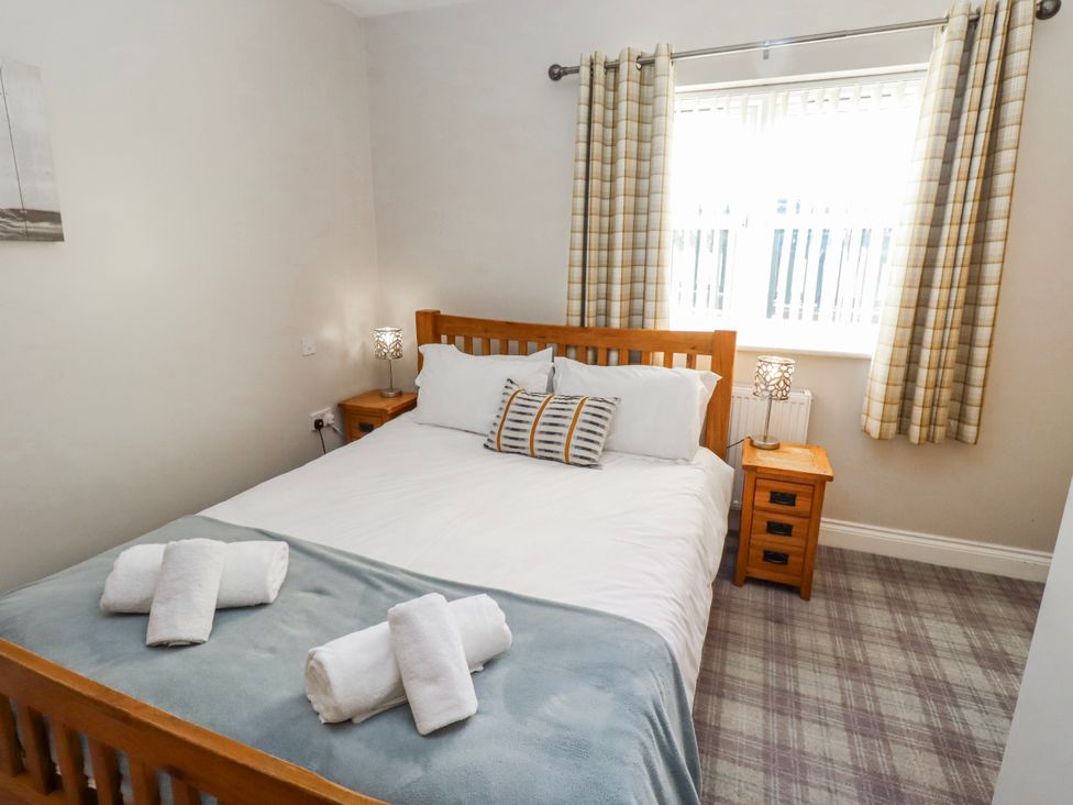 A bedroom with a bed and bedside tables at Goosander in Bamburgh