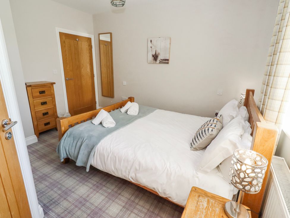 A bedroom with a bed and furniture at Goosander in Bamburgh