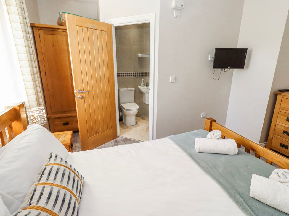 A bedroom with a bed and a wardrobe at Goosander in Bamburgh