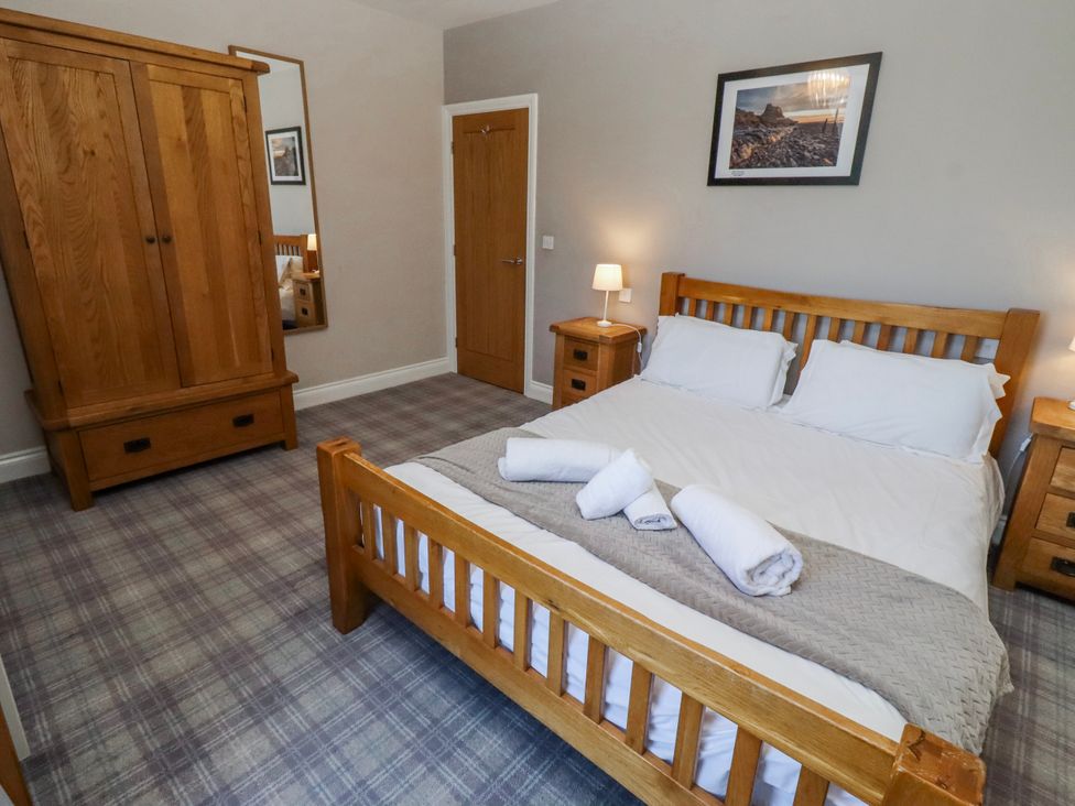 A bedroom with a bed and wardrobe at Goosander in Bamburgh