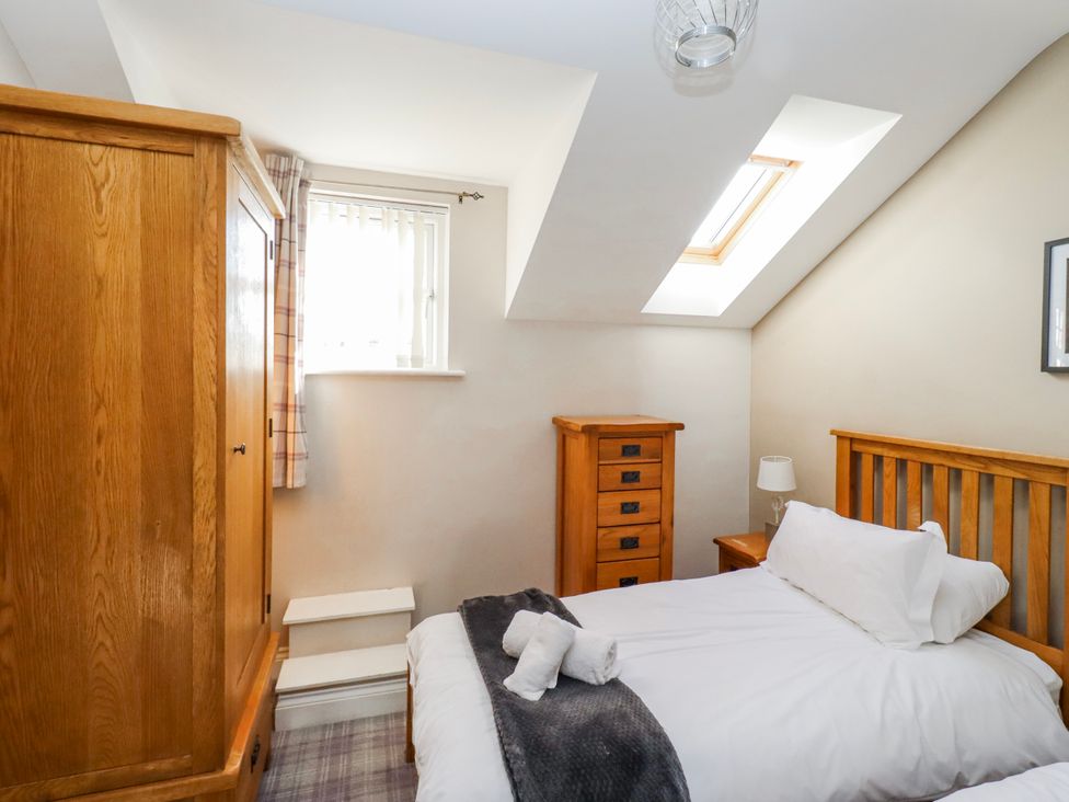A bedroom with a bed and wardrobe at Goosander in Bamburgh