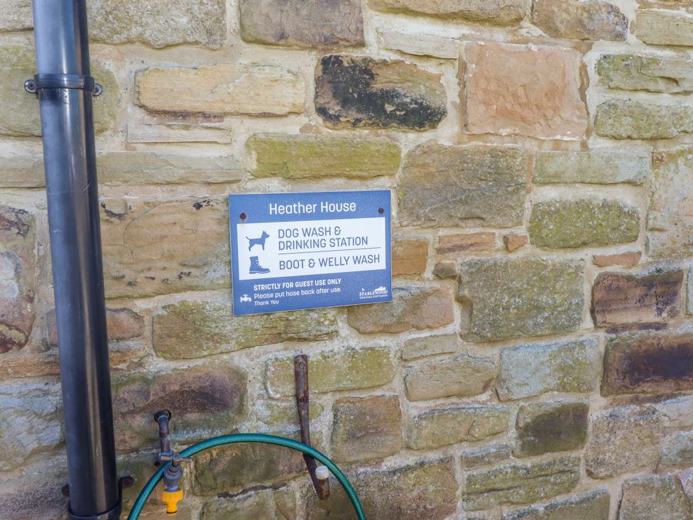A sign indicating a dog wash and drinking station at Heather House