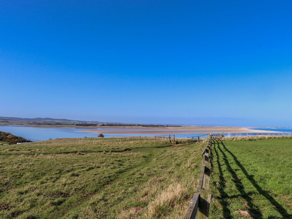 A landscape view with a fence and water at Goosander in Bamburgh