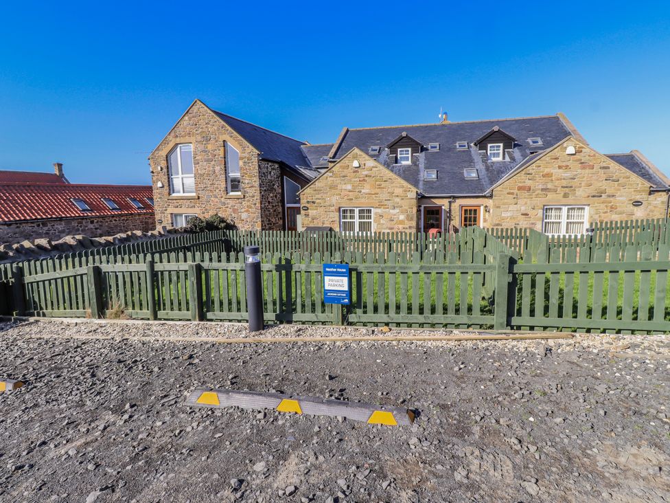 A house with a fence and parking sign at Jackdaw in Bamburgh