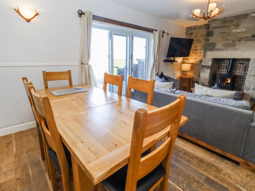 A dining room with a wooden table and chairs at Jackdaw in Bamburgh