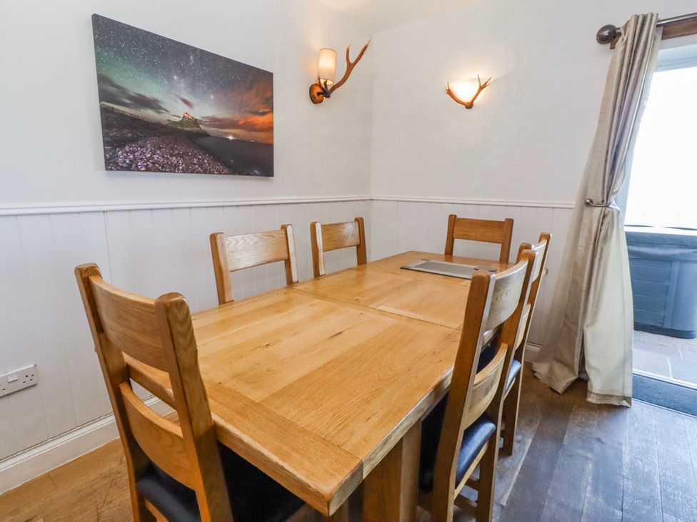 A dining room with a wooden table and chairs at Jackdaw in Bamburgh