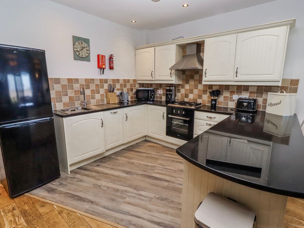 A kitchen with cabinets and appliances at Jackdaw in Bamburgh