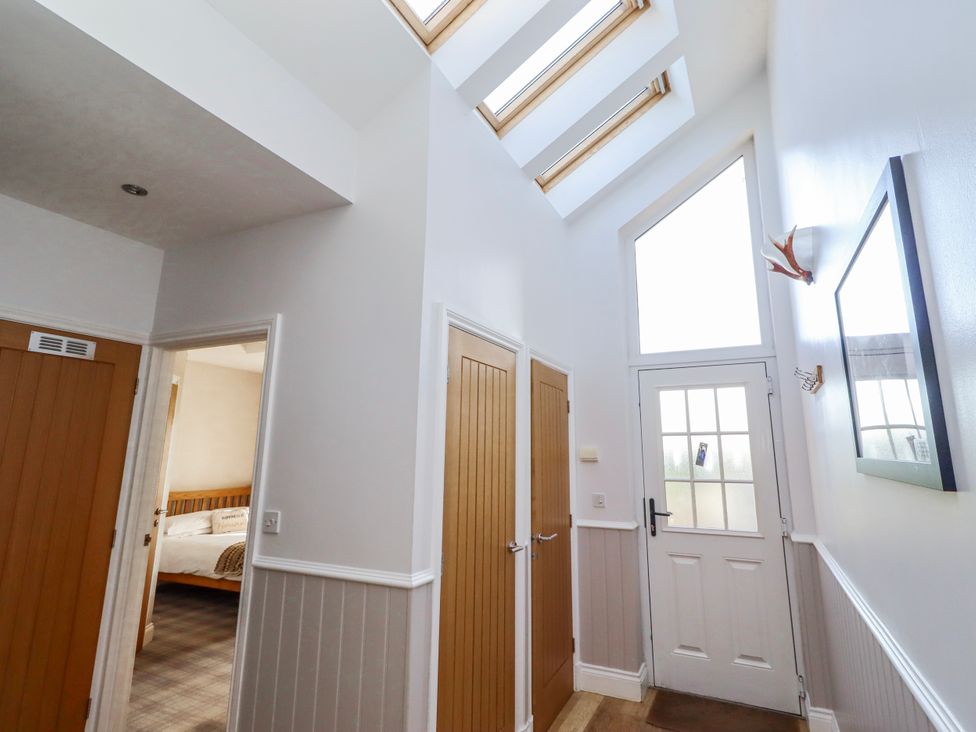 A hallway with doors and skylights at Jackdaw in Bamburgh