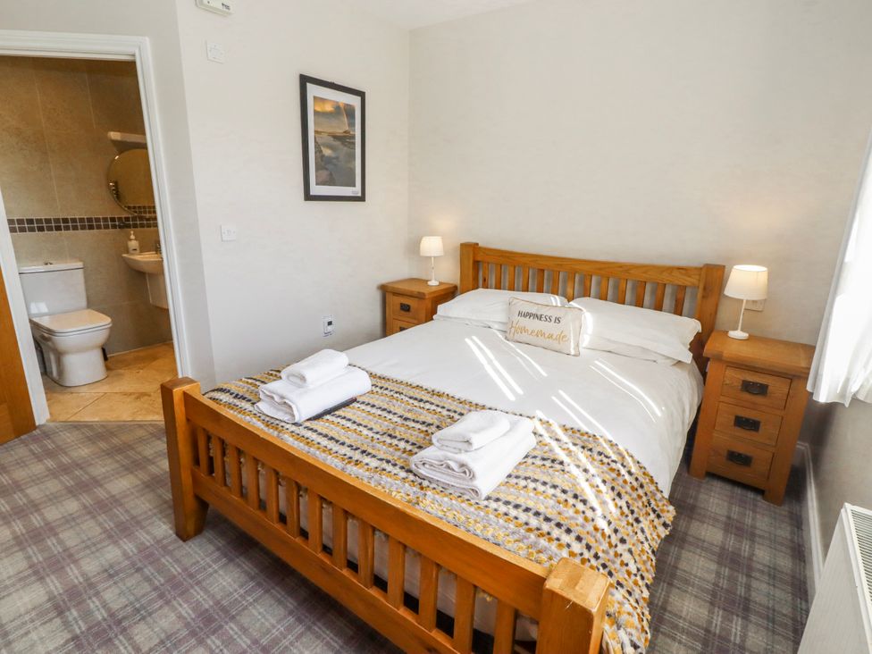 A bedroom with a double bed and an ensuite bathroom at Jackdaw in Bamburgh