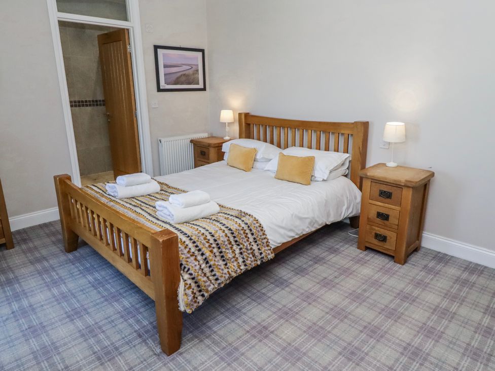 A bedroom with a bed and nightstand at Jackdaw Bamburgh