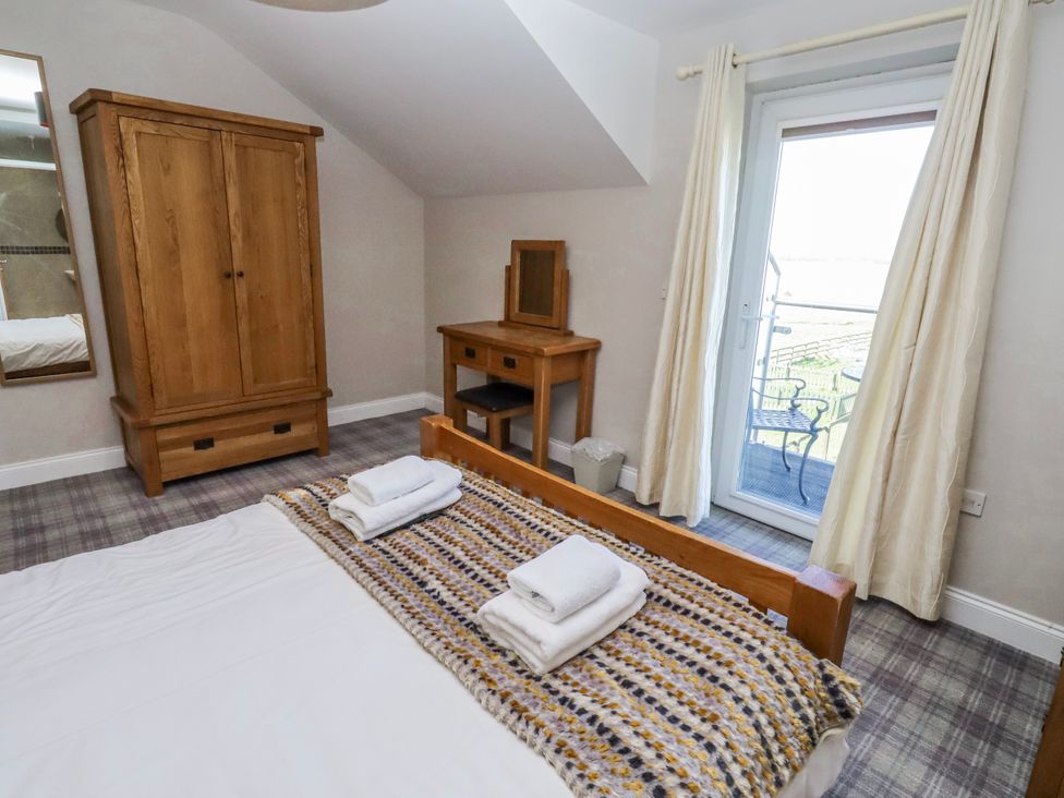A bedroom with a bed and wardrobe at Jackdaw in Bamburgh