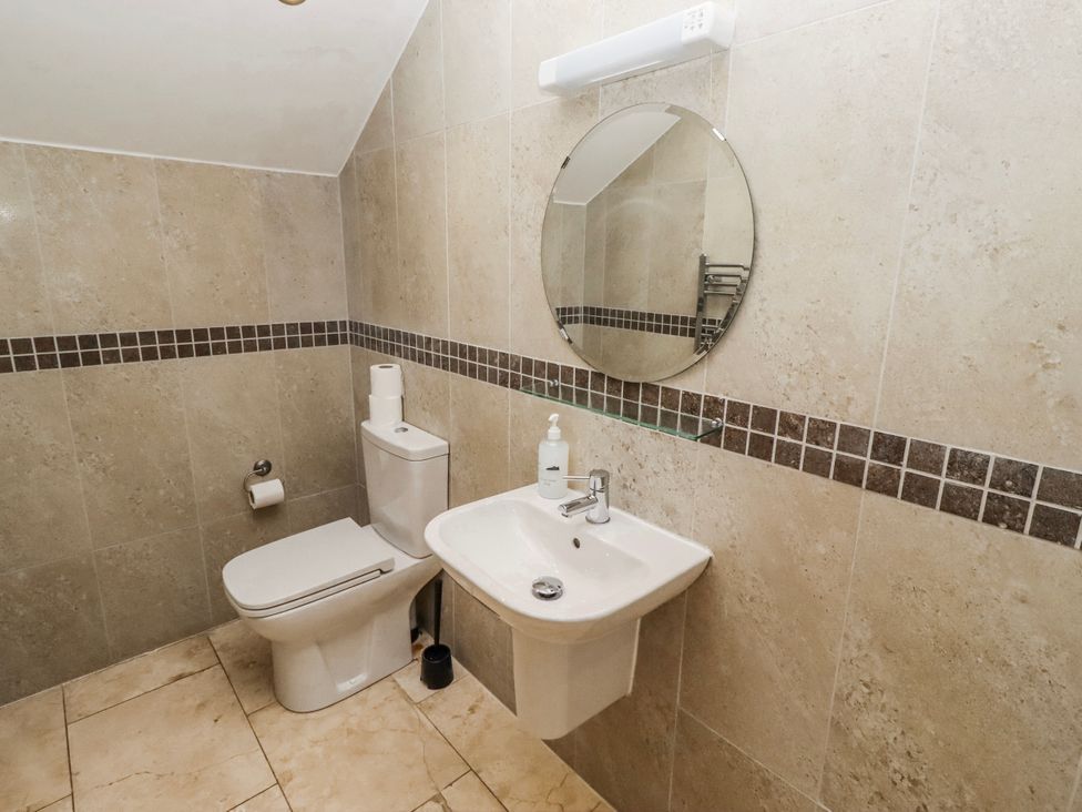 A bathroom with a toilet and hand basin at Jackdaw in Bamburgh