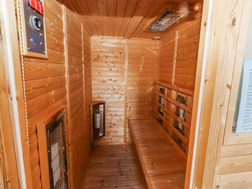 A sauna with wooden benches and heating elements at Jackdaw in Bamburgh