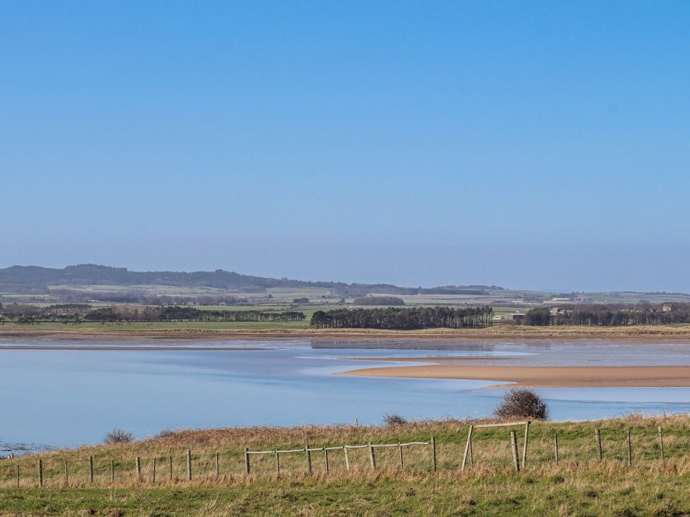 A landscape with a river and fields at Jackdaw in Bamburgh