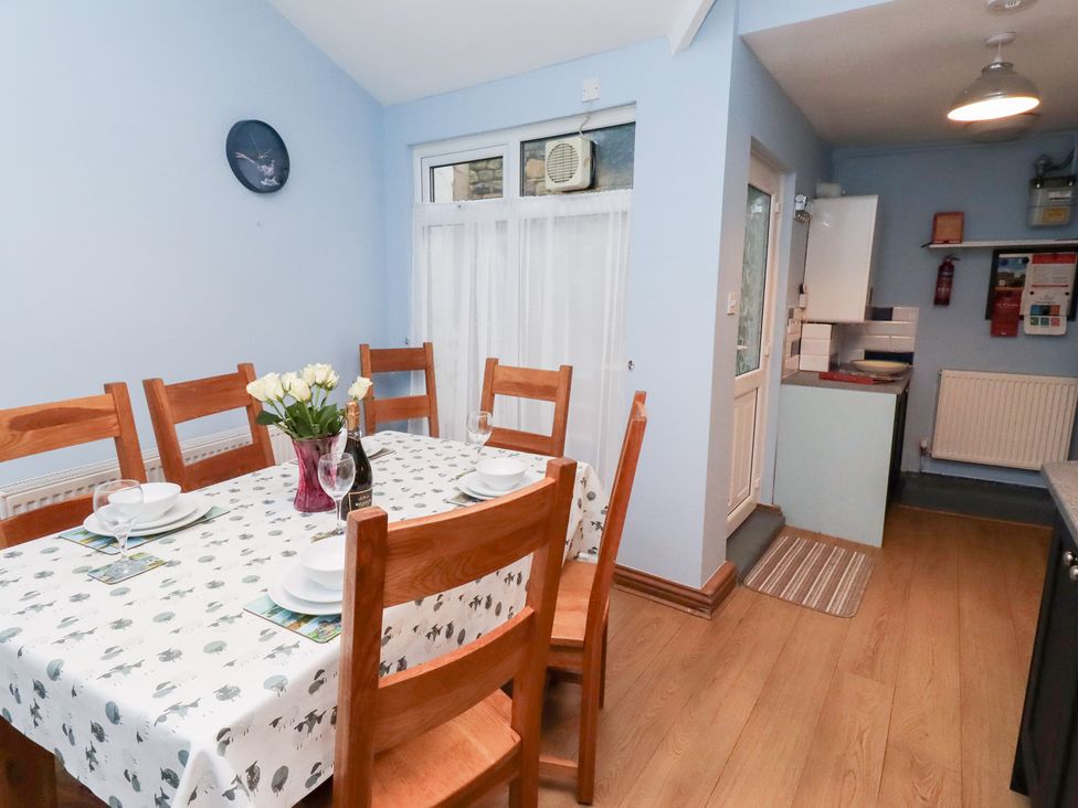 A dining room with a table and chairs at Riverside Cottage in Warkworth