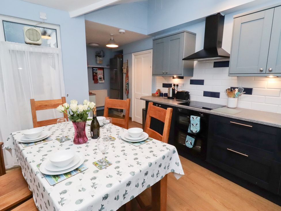 A kitchen with a dining table and chairs at Riverside Cottage in Warkworth
