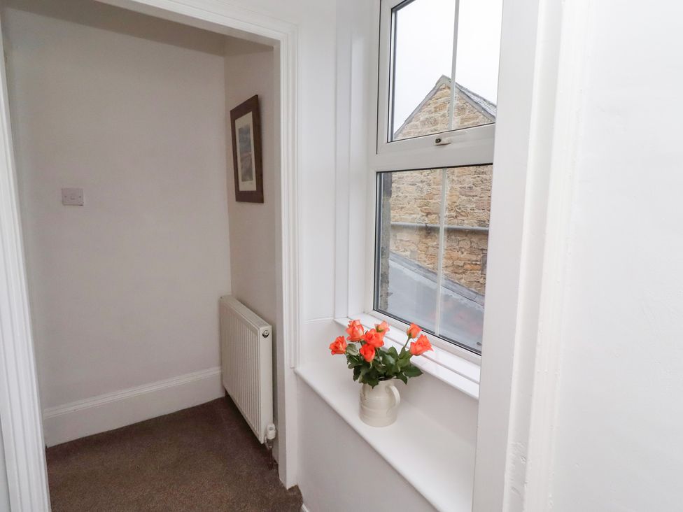 A hallway with a window and a flower pot at Riverside Cottage Warkworth