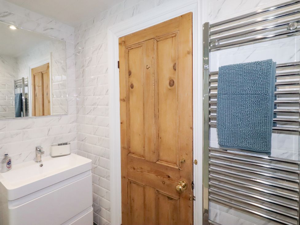A bathroom with a basin and mirror at Riverside Cottage in Warkworth