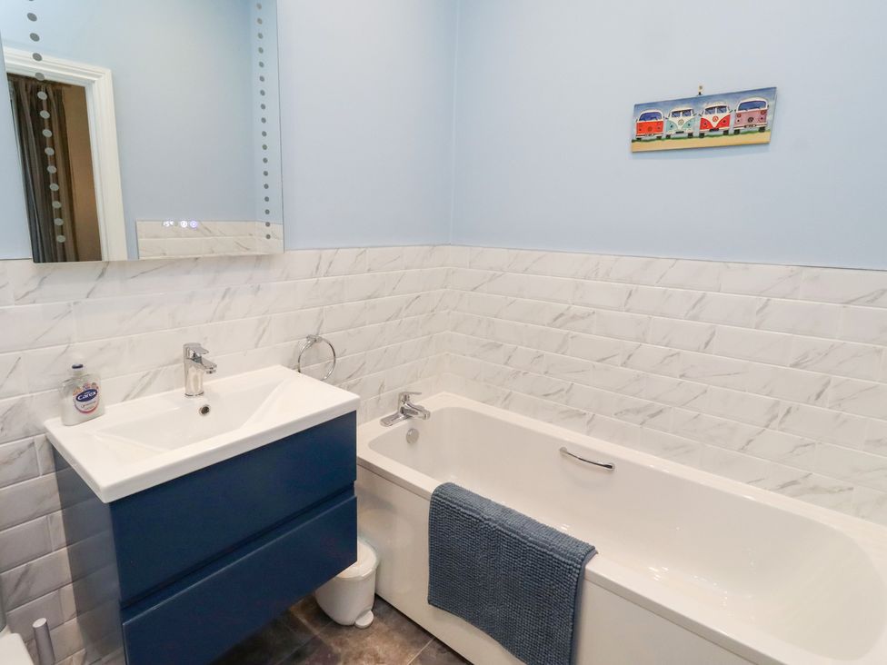 A bathroom with a bathtub and sink at Riverside Cottage in Warkworth