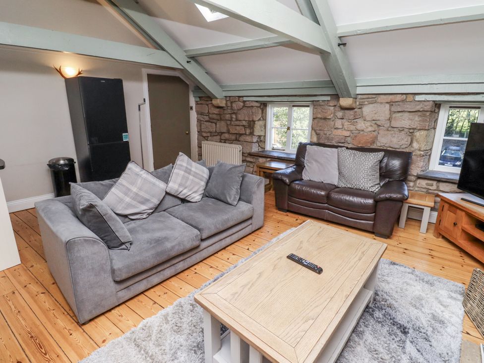 A living room with sofas and a television at Old Mill in Lucker